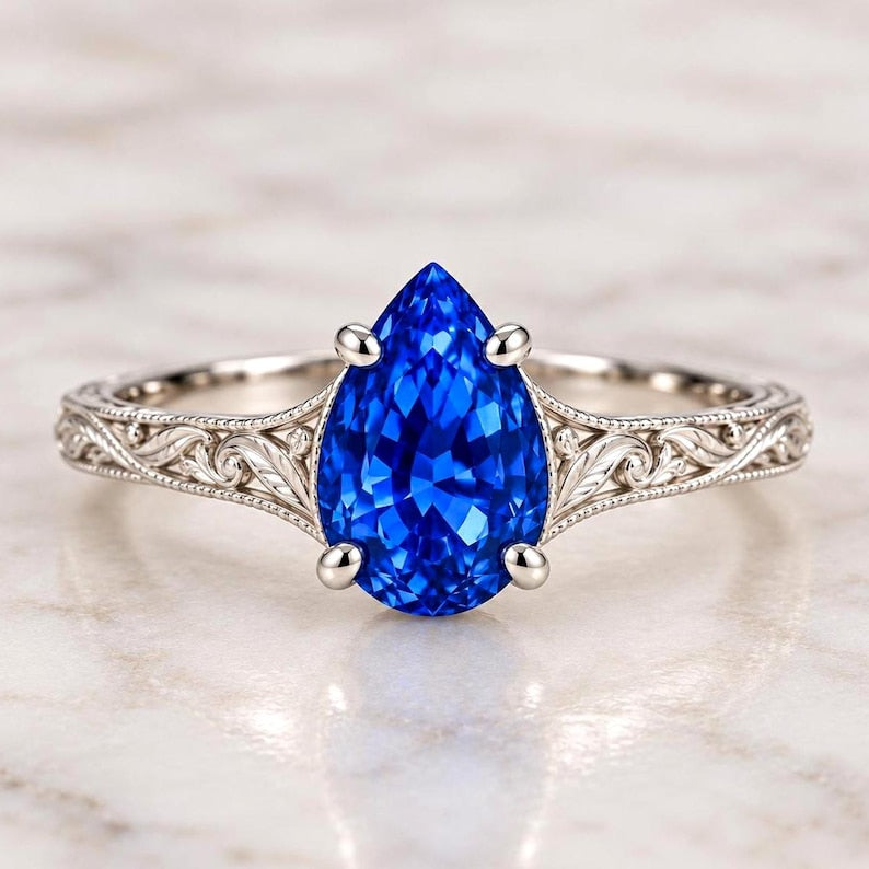 Pear-shaped blue sapphire ring with engraved shoulders